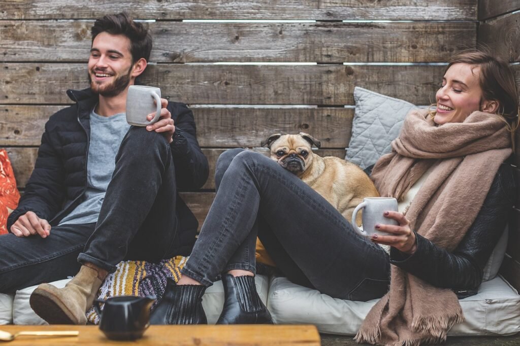 merry christmas, man, woman, dog, pet, pug, owners, couple, relationship, warm clothes, cozy, scarf, jackets, jeans, boots, fashion, people, happy, love, female, young, male, adult, animal, caucasian, happiness, romantic, portrait, smile, smiling, girlfriend, date, boyfriend, together, person, lovers, sitting, relaxing, rustic, cushions, couch, laughing, enjoying, coffee