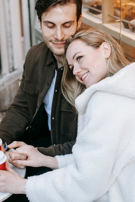 High angle of happy young couple in casual wear spending romantic date in cafe